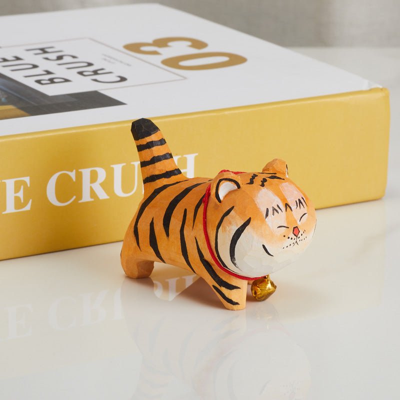 Handcrafted wooden tiger figurine with a red collar and bell front view