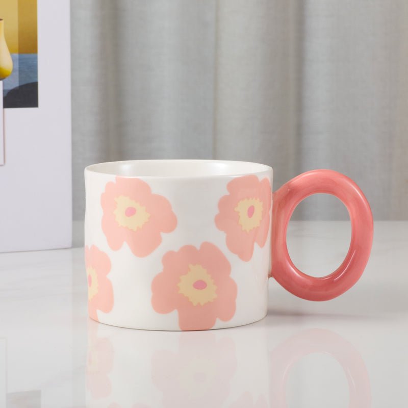 Floral-patterned ceramic mug with pink handle