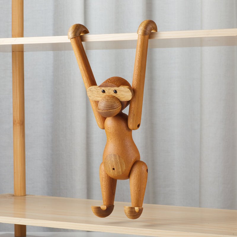 Wooden monkey figurine hanging on a shelf