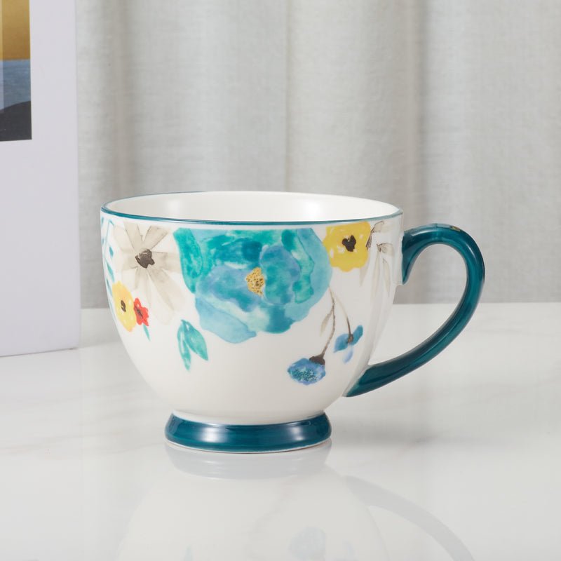 Side view of floral-patterned ceramic mug with blue handle