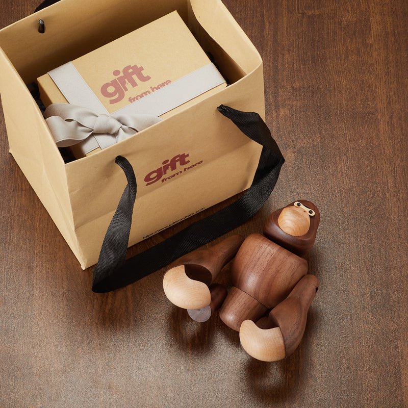 Wooden gorilla figurine and gift box inside a shopping bag